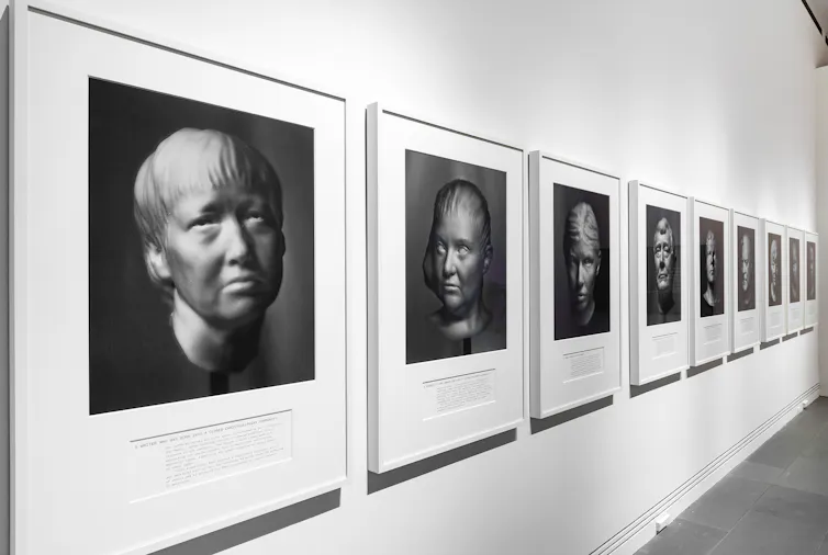 Portrait images line a gallery wall.