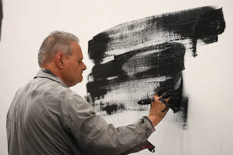 Parr paints a wall black.