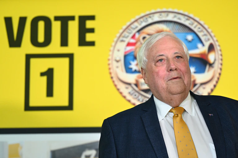 Clive Palmer in front of a Trumpet of Patriots poster