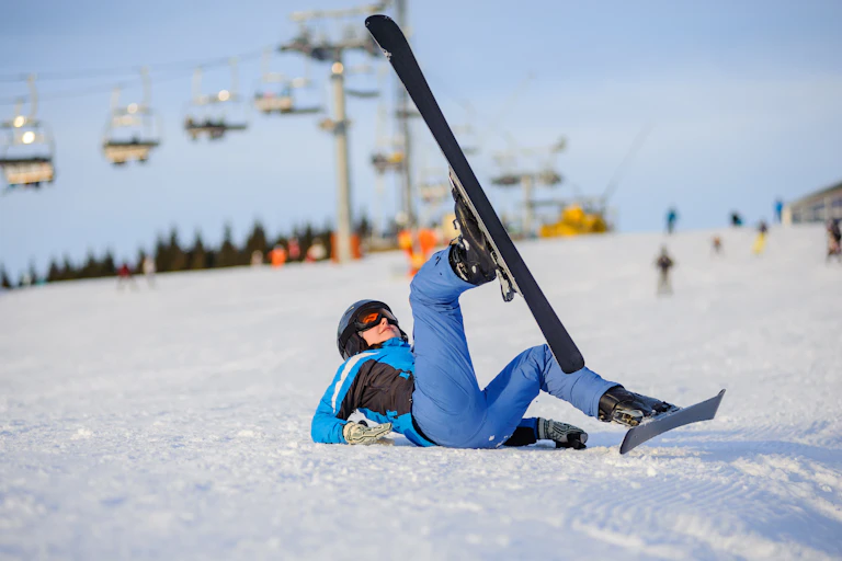 Une femme par terre après une chute en ski.