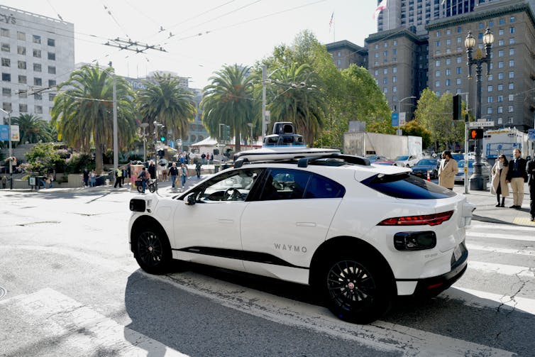 white waymo robotaxi drives through san franciso