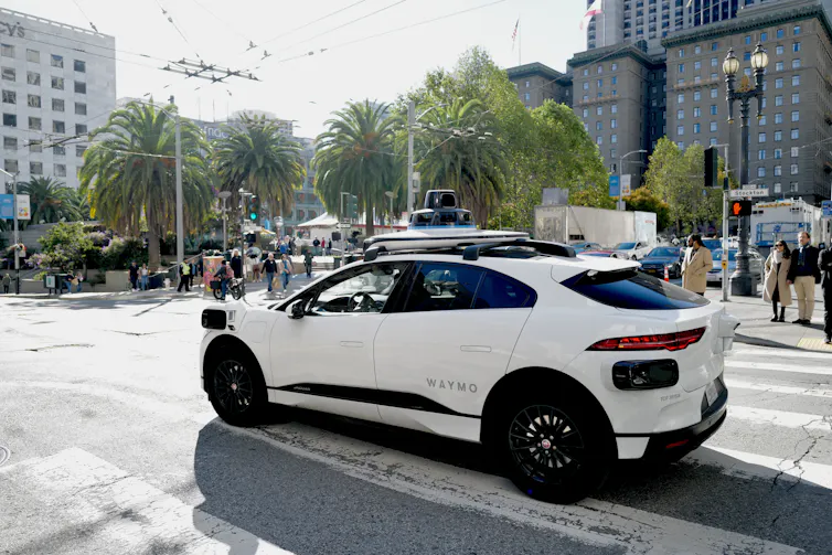 white waymo robotaxi drives through san franciso