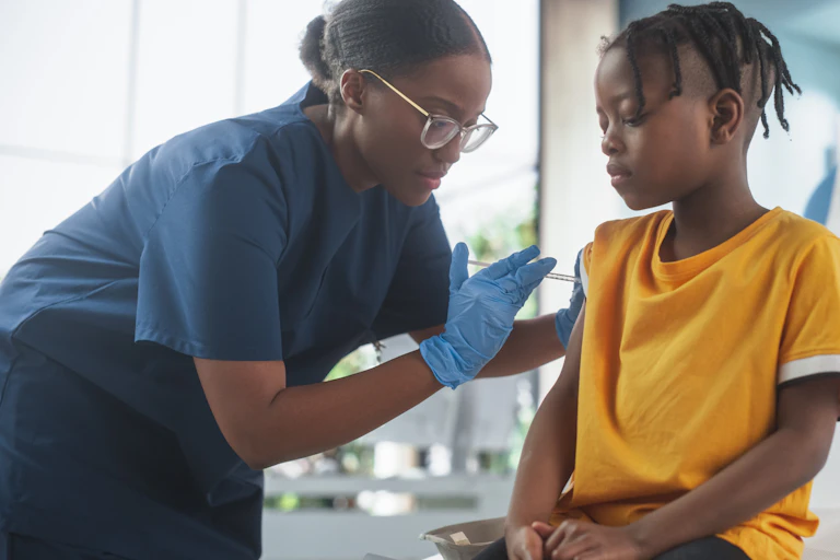 A medic vaccinates a young boy.