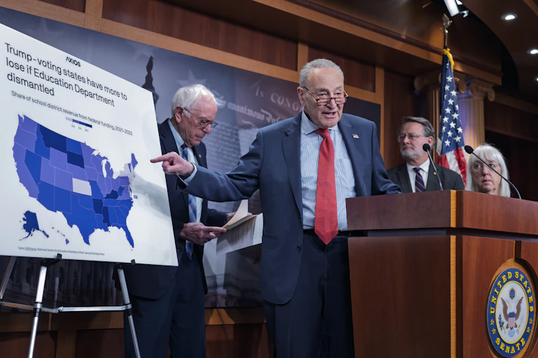 Senator Chuck Schumer speaks in front of a lectern.