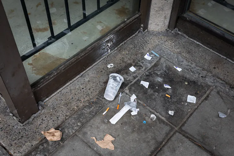 Aiguille usagée, seringue, cigarette et déchets plastiques jetés dans la rue par des toxicomanes
