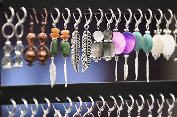 La fila de aretes hechos a mano colgando con un estante