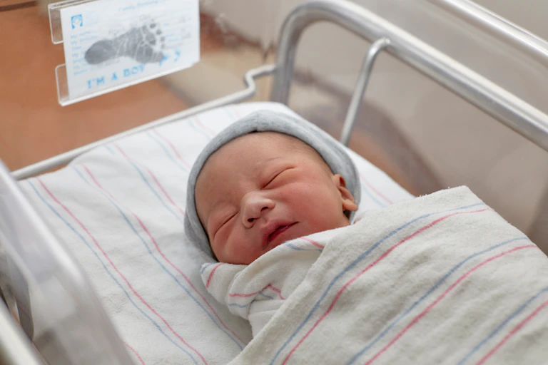 Newborn baby in bassinet in hospital