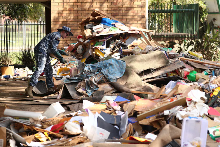 An ADF member adds to a pile of rubbish and debris in a school playground.