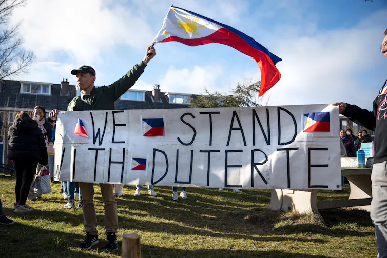 Duterte supporters holding a banner outside a prison in the Netherlands.