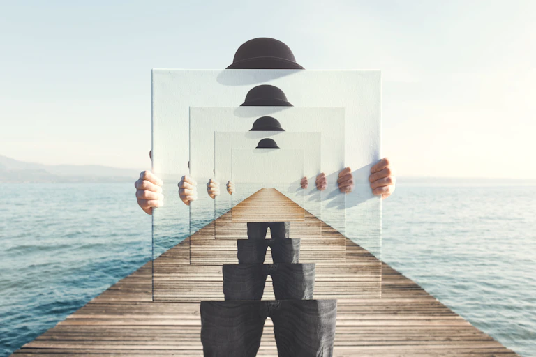 Surreal image of person in bowler hat on a pier