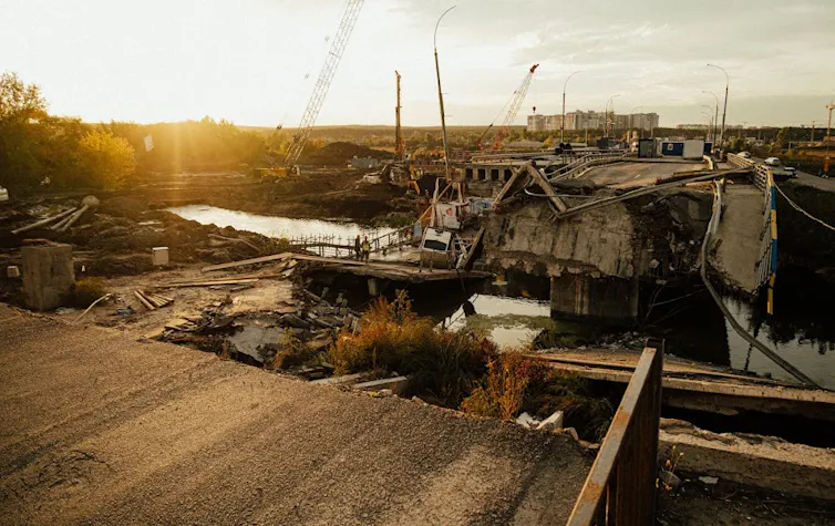 A destroyed bridge at sunset.