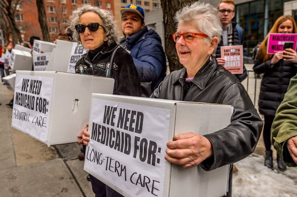 Women carry boxes labeled 'We need Medicaid for Long Term Care' and We need Medicaid for Pediatric Care' at a protest in 2017.