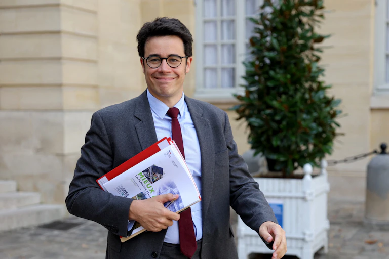 Un homme en costume tient une brochure où on lit «planification écologique»