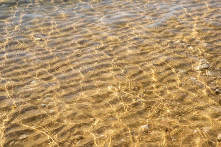 sun shining on shallow sea, sandy seabed