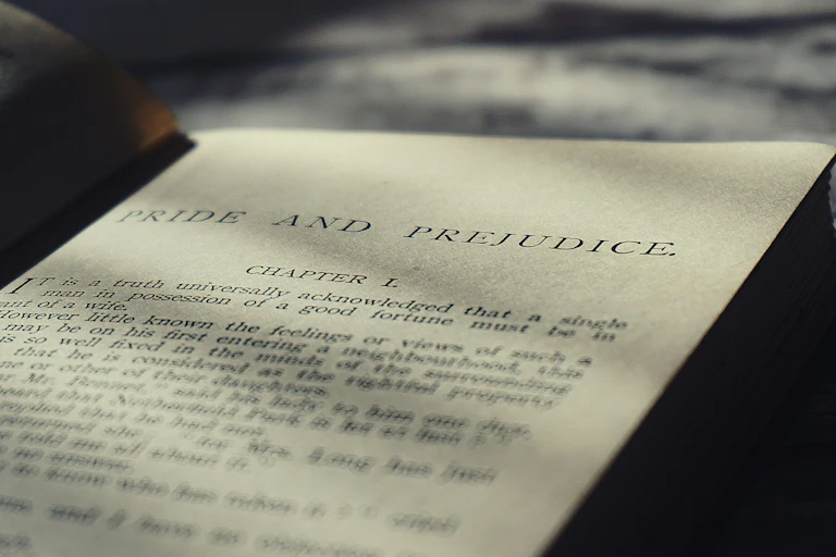 An open book with the printed words 'Pride and Prejudice' as the title, with printed text underneath.