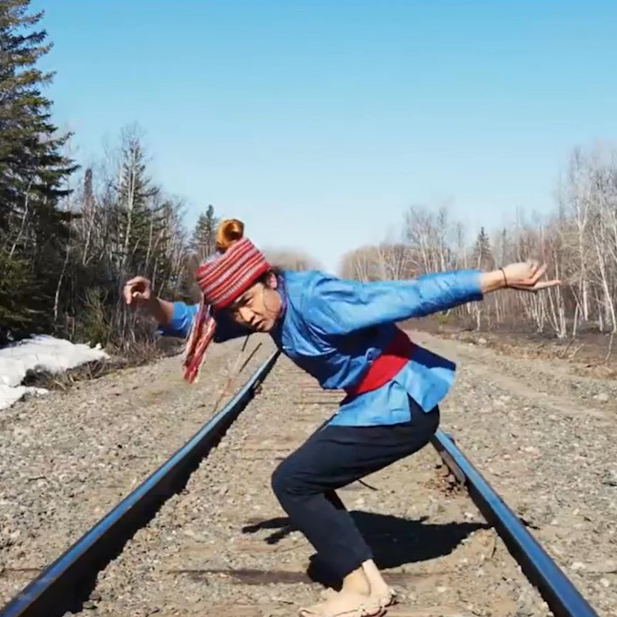 Un homme danse au milieu d'un paysage naturel.