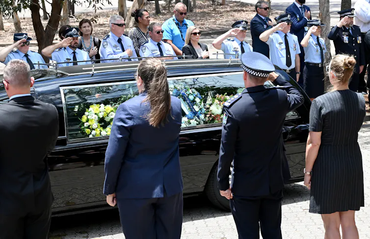 Police guard of honour around a hearse.