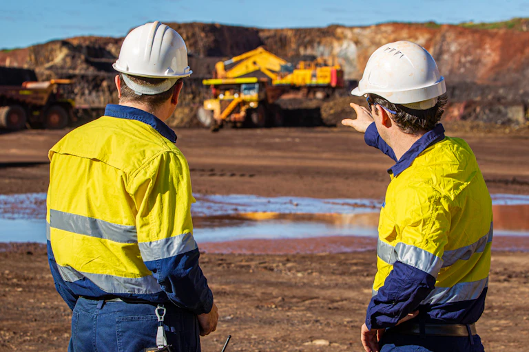 two workers talking wearing hi vis clothing on a mine site