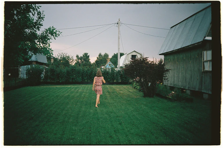 A woman walks in her old garden.