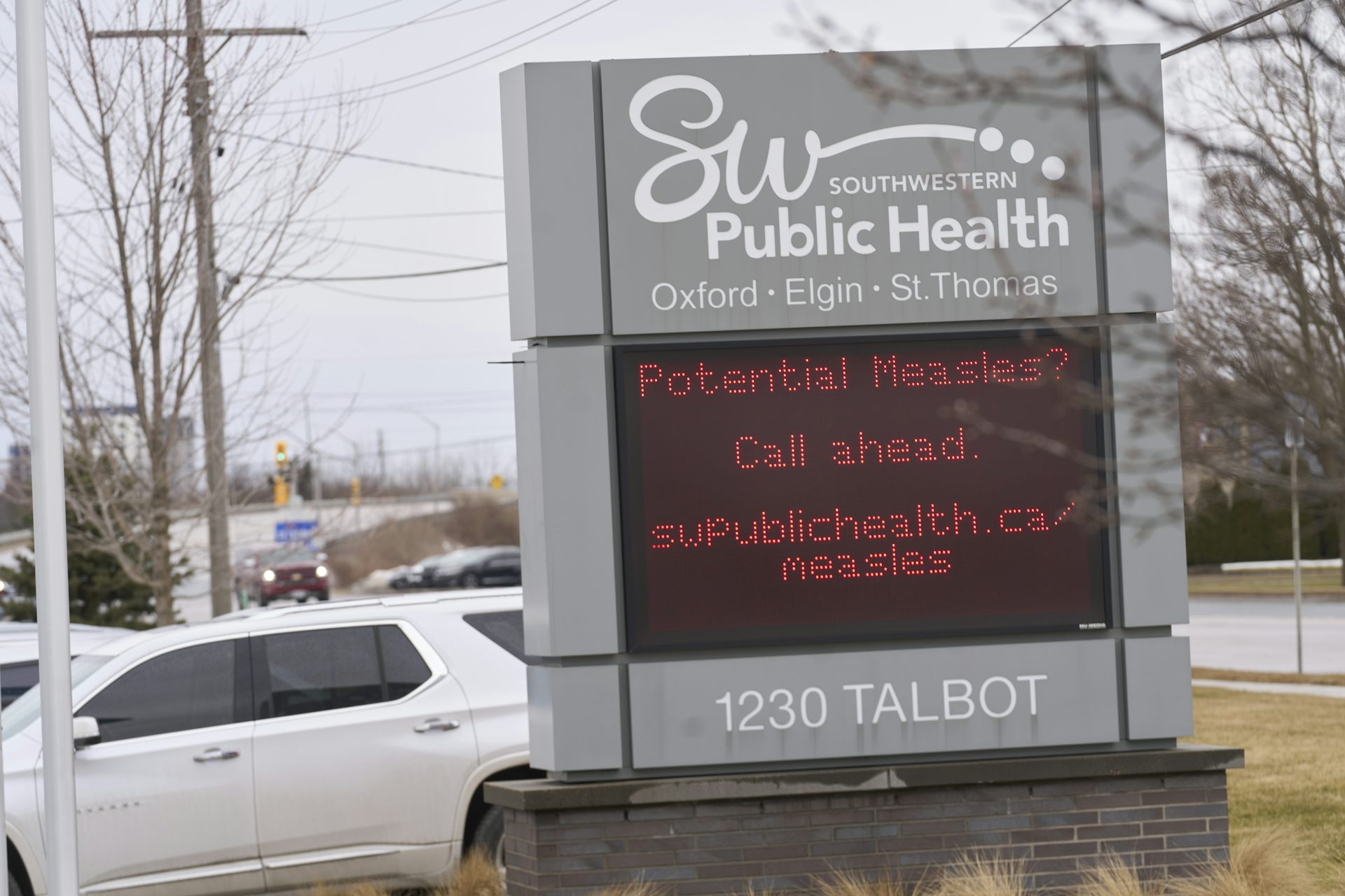 An electronic outdoor sign with a warning about measles
