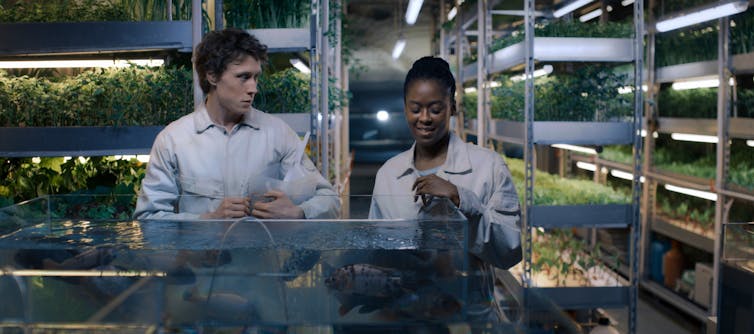 George MacKay and Moses Ingram in a lab that is for growing vegetables.