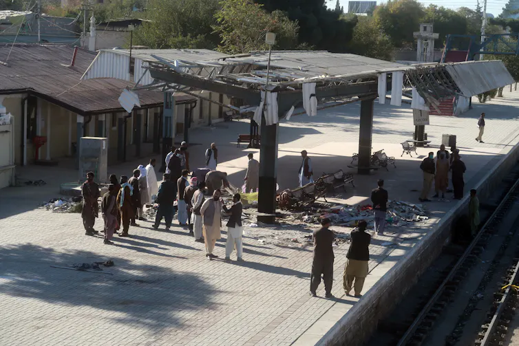 Pakistani security officials inspect the scene of a suicide bomb blast at a railway station.