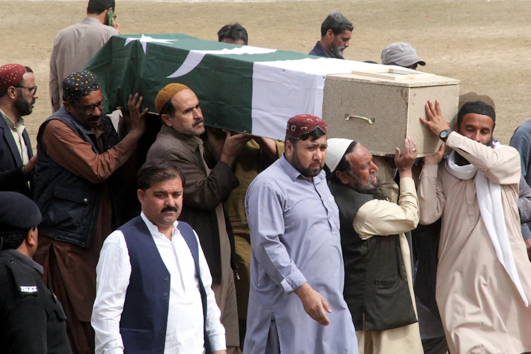 A group of Pakistani men carrying a coffin covered with a Pakistan flag.