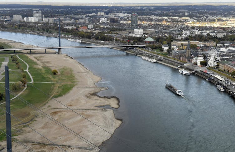 A barge moves through a section of river narrowed by drought.