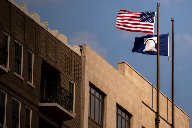 A U.S. flag and Heritage Foundation flag fly in front of a building.