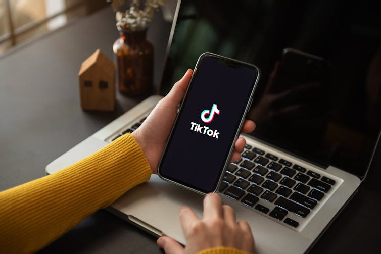 Close up of a hand holding a smartphone displaying tiktok