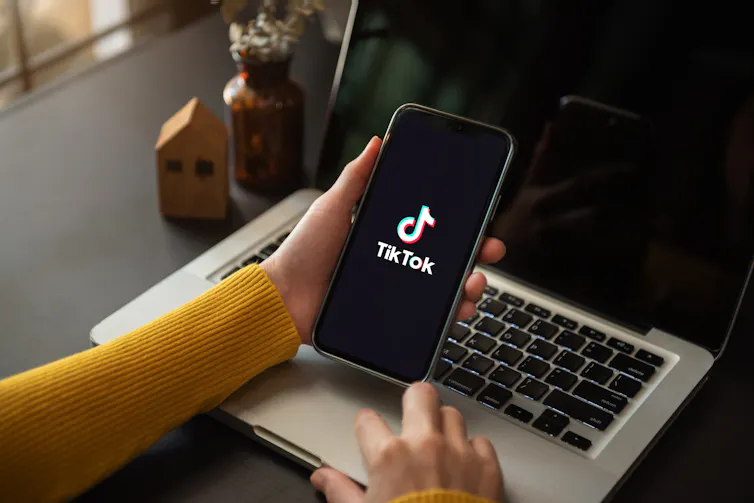 Close up of a hand holding a smartphone displaying tiktok