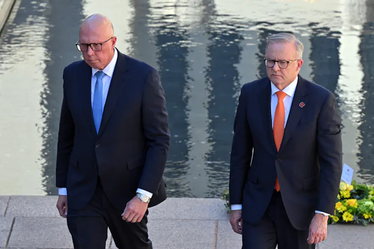 Two men in suits walk next to each other