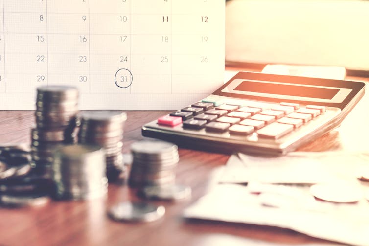 Stacks of coins and a calculator on a desk
