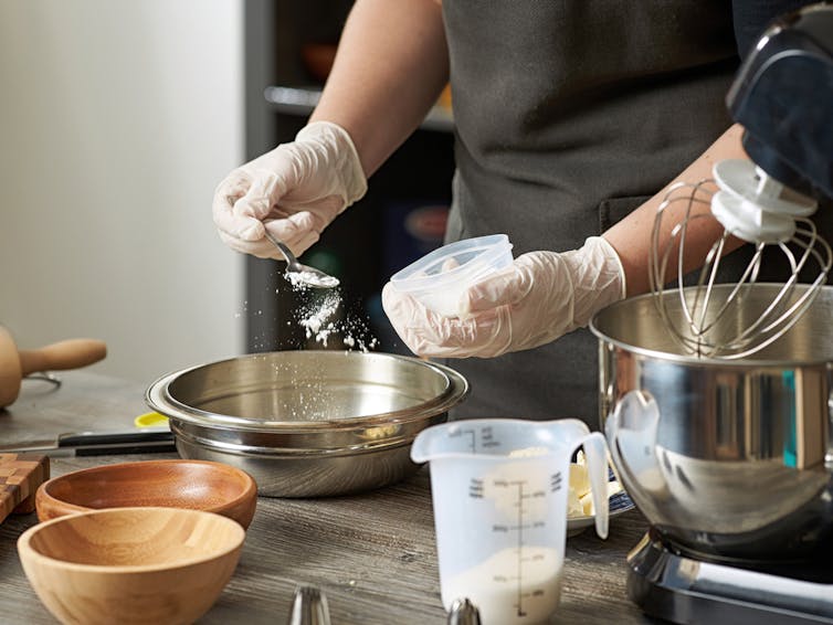 A person in a kitchen mixing ingredients for a batter.