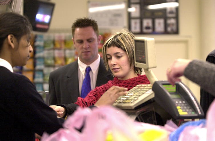 A woman at the cash register of a supermarket in the early 2000s