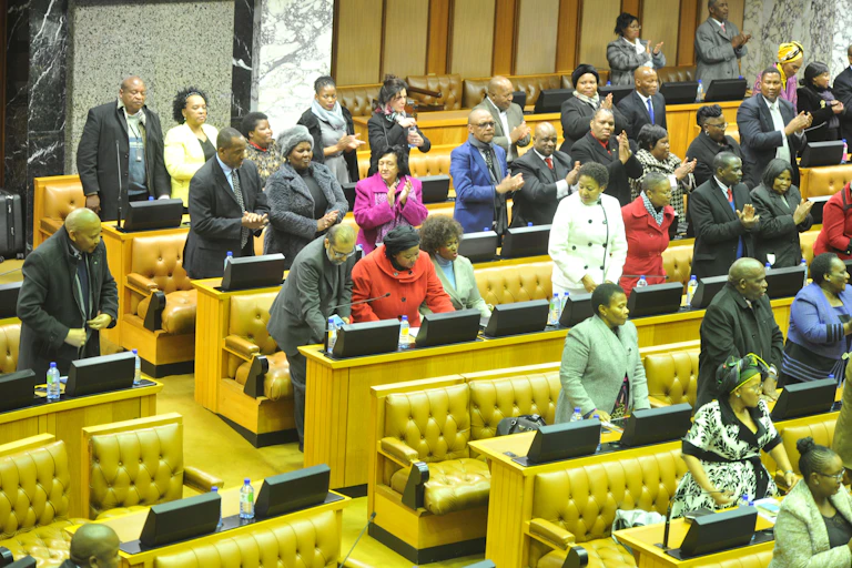 Men and women stand in rows of seating