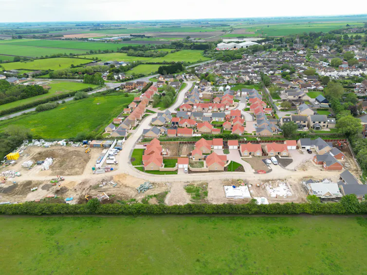 Aerial shot of new houses being built on the edge of a village in England