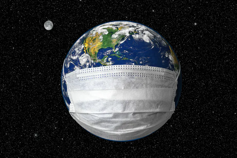 Um globo terrestre envolto numa máscara médica em um fundo de céu estrelado.