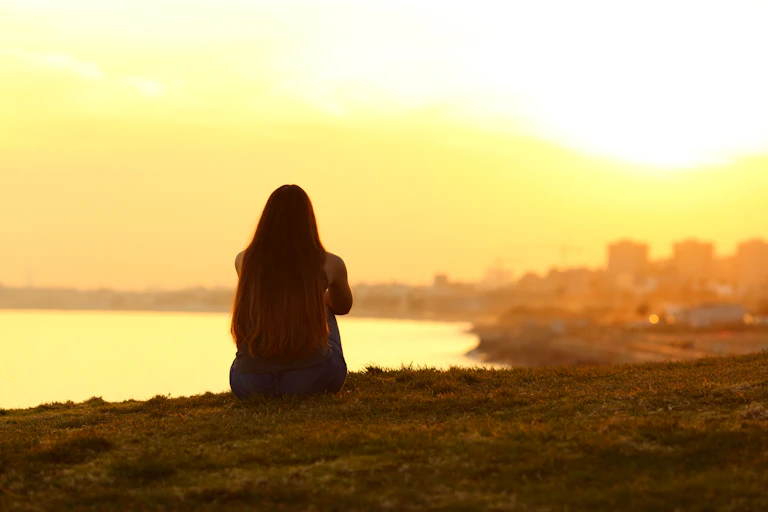 Girl sat looking at city in distance
