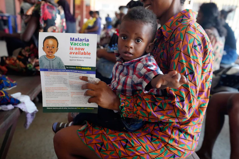 Child sits on mother's lap at a vaccine clinic