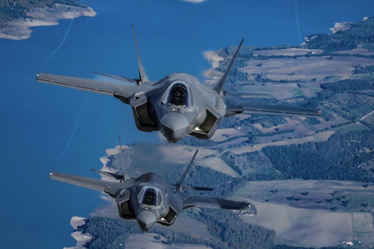 F35 jets flying over a green landscape.