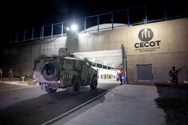 An armored vehicle outside a large concrete building.