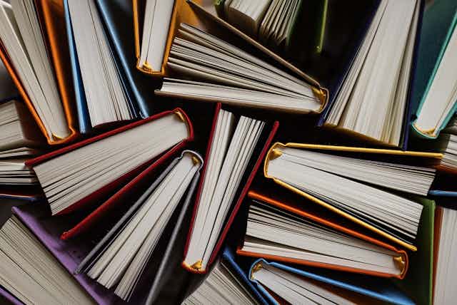 Top view of books with colourful covers opened on their side.