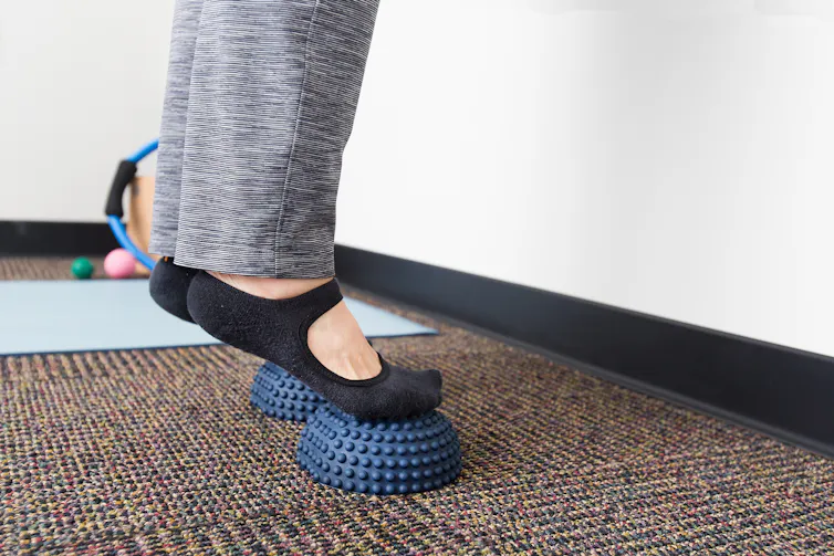Person does heel-raises on spiky balls