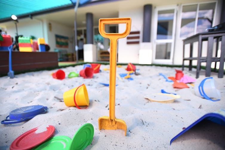 A sandpit with buckets and shovel at a daycare centre.