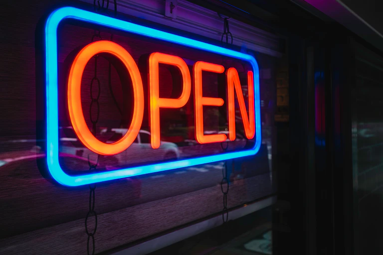 Open sign in a window in red and blue neon light.
