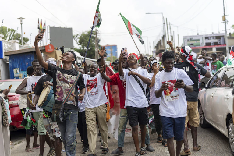 A group of young man celebrate in the street.