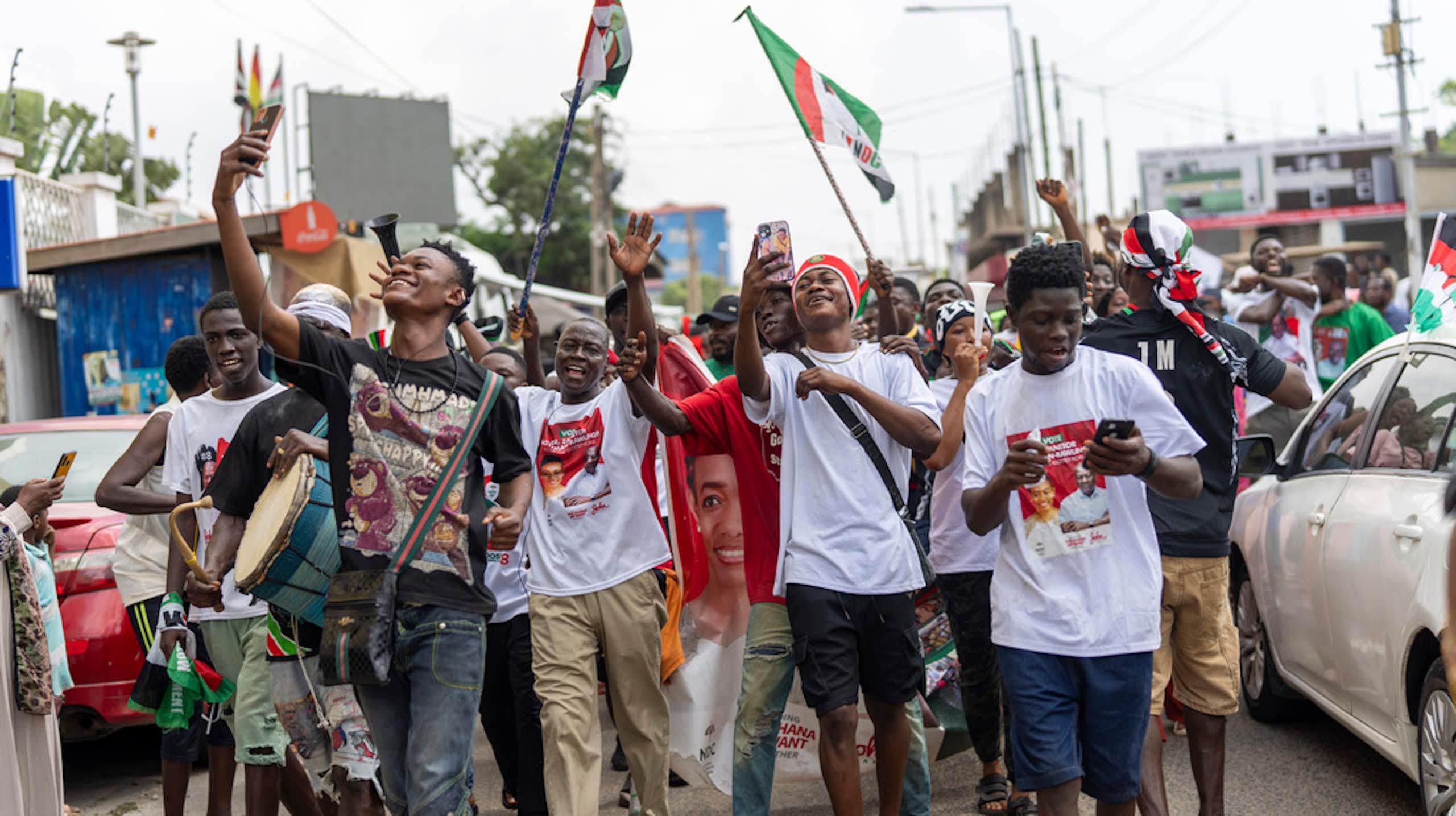 A group of young man celebrate in the street.