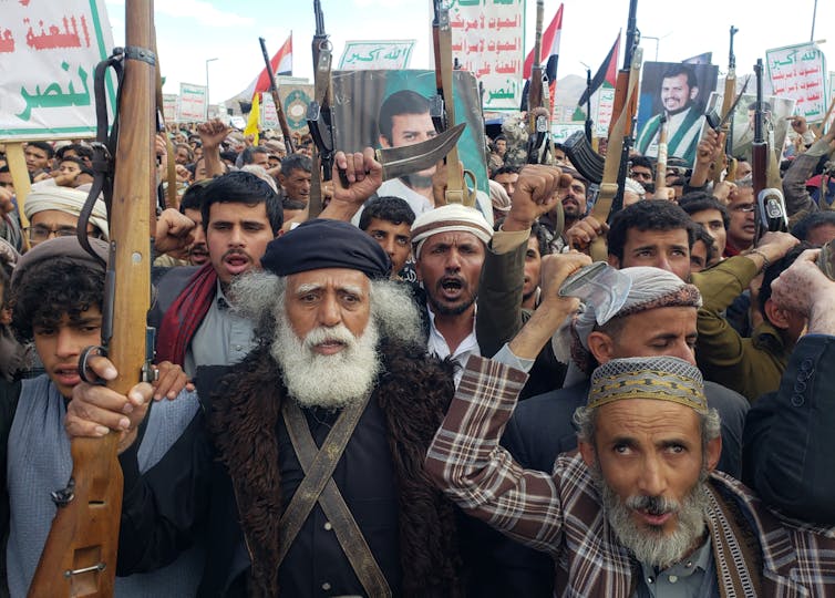 Houthi supporters shout slogans and hold up their weapons during a protest against the US airstrikes on Houthi positions, in Sana'a, Yemen, 17 March 2025.