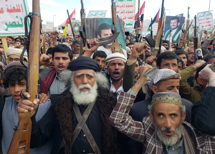 Houthi supporters shout slogans and hold up their weapons during a protest against the US airstrikes on Houthi positions, in Sana'a, Yemen, 17 March 2025.